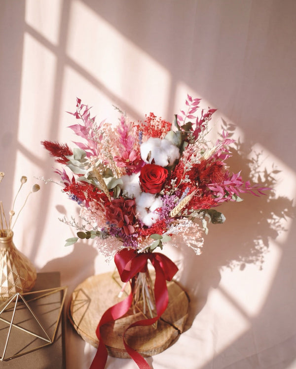 Eternal Red Bridal Bouquet — preserved red rose, white cotton bolls and dried red foliage, tied with a red ribbon.