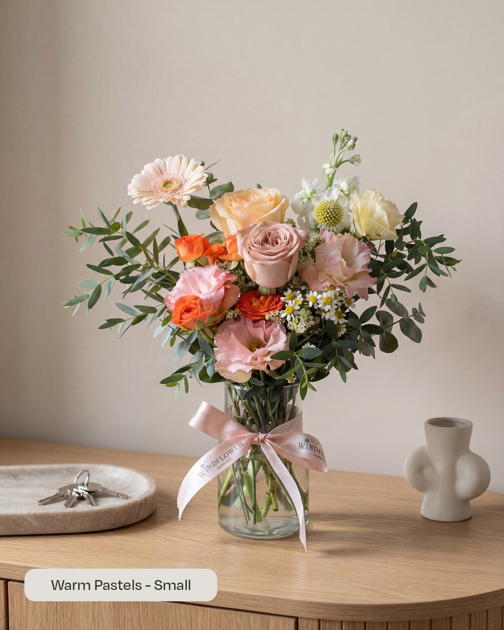 Warm pastel Daily Surprise fresh flowers arranged in a glass vase