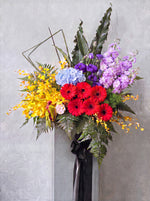 Radiant Success congratulatory flower stand - red gerbera daisies, blue hydrangea, lilac matthiola, yellow orchids