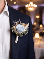 Corporate Boutonniere (Preserved light blue rose) worn on a navy blazer at a corporate gala