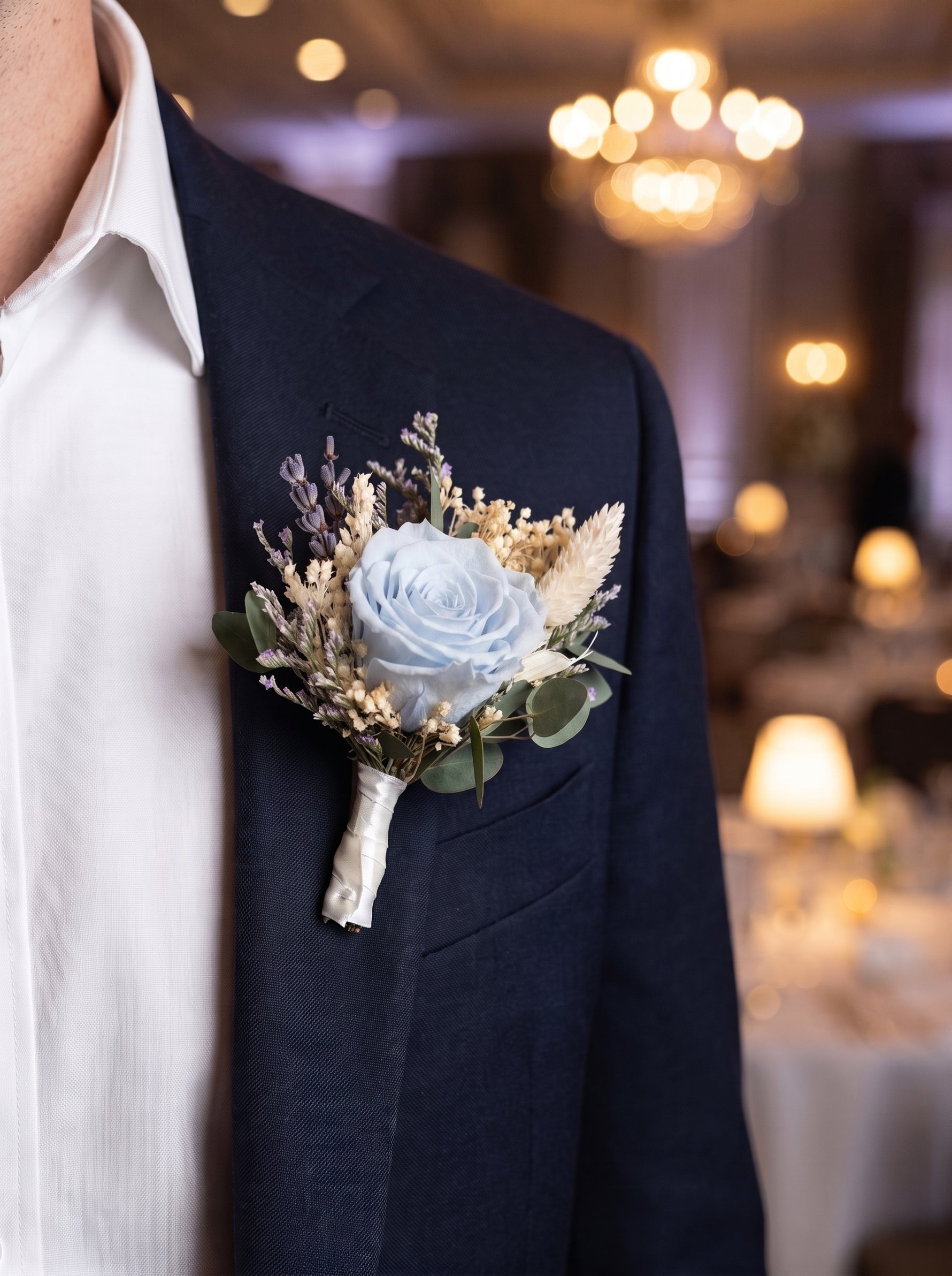 Corporate Boutonniere (Preserved light blue rose) worn on a navy blazer at a corporate gala