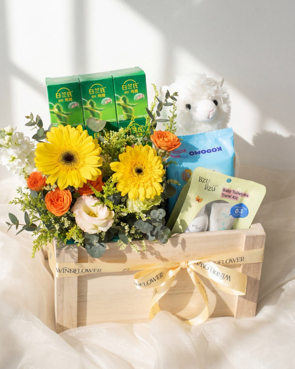 Premium baby hamper Singapore with BRAND'S Bird's Nest, Kodomo baby wipes, BZU BZU toiletries, white alpaca plush and yellow gerbera bouquet in a Windflower wooden crate
