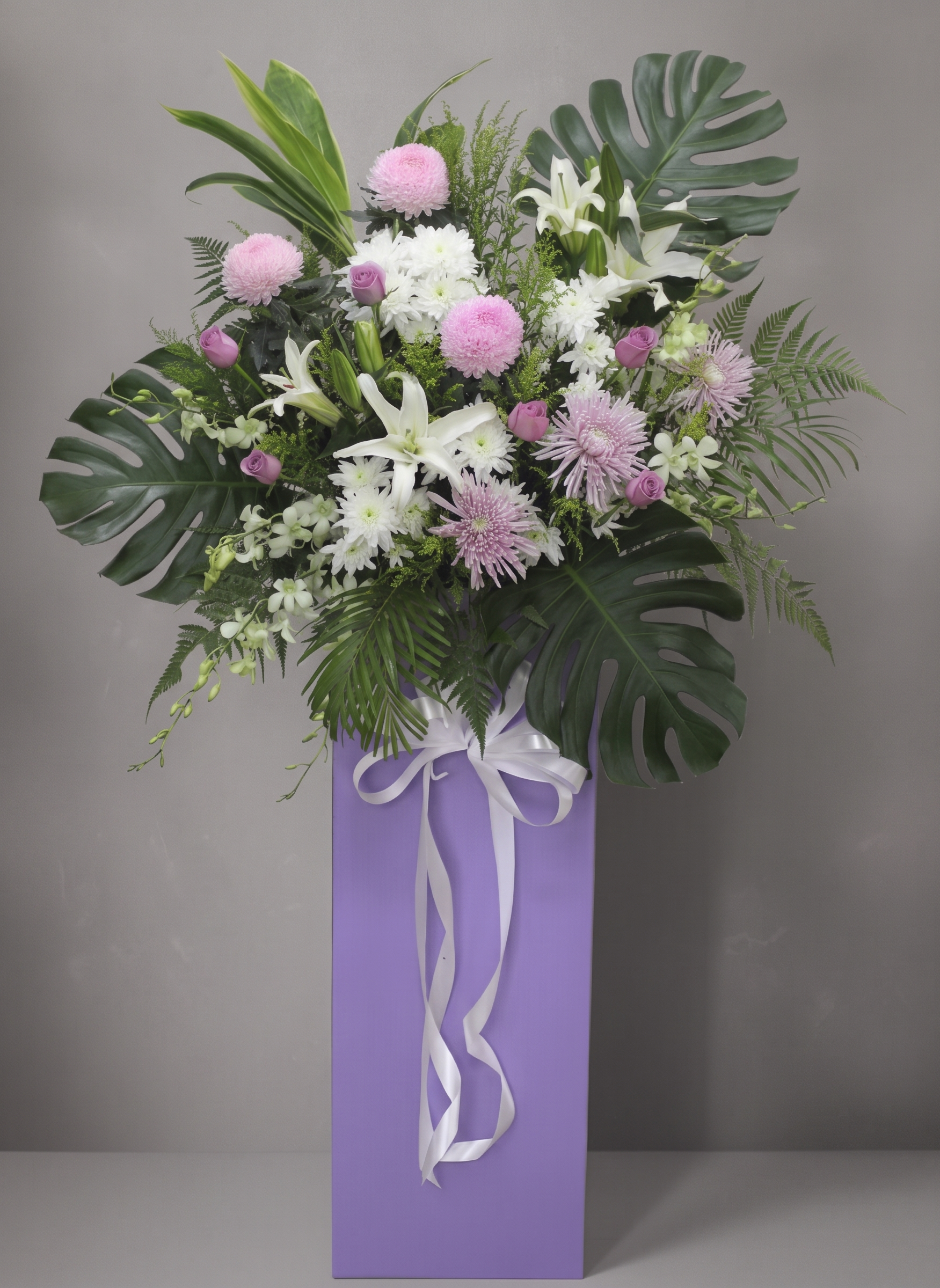 Blush Reverence condolence flower stand, white draping ribbon, trimmed foliage
