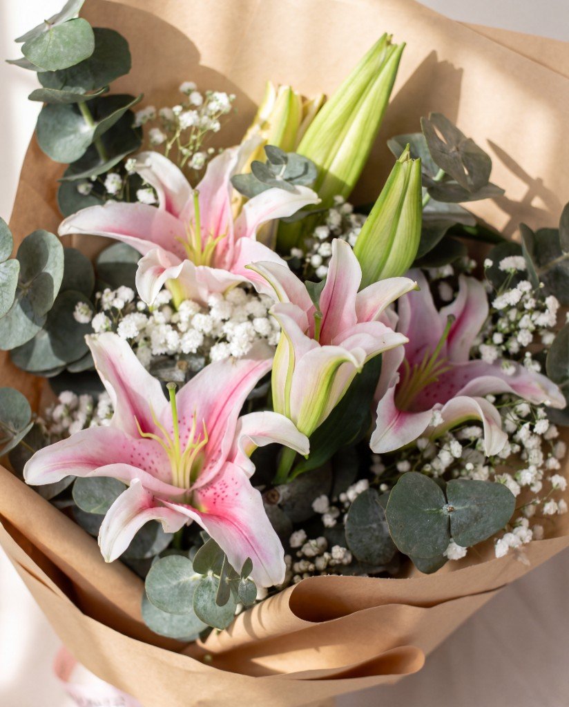 All Smiles — close-up of pink lilies, baby's breath and eucalyptus