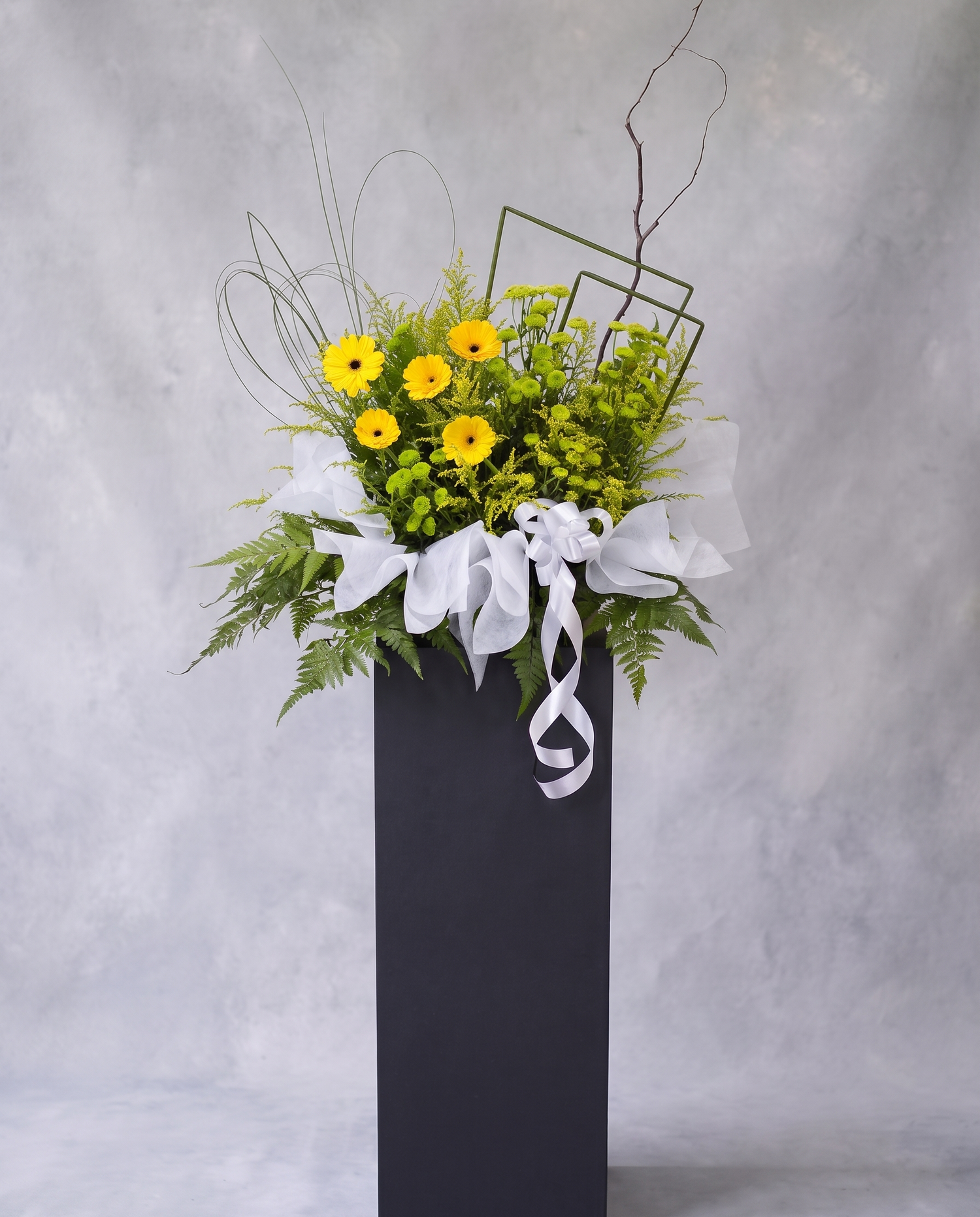 Sunlit Grace condolence flower stand, full view with cool grey backdrop