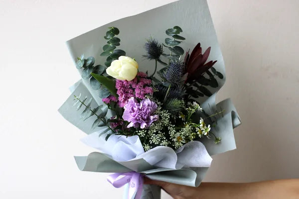 Purple carnation and eryngium bouquet with eucalyptus at floral bar